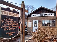 Sign in front of building reads "Serving the Sugarcreek area and Amish Mennonite communities throughout the Americas".