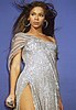 Beyonce Knowles in silver sequined dress with hair flying in the air
