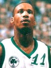 Headshot of a man wearing a white basketball jersey with the number "11" on the front