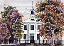 Drawing of a two story white building with a cupola on the roof upon which is a cross. It is behind a fence and surrounded by two large trees.