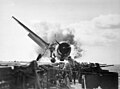 Image 16Crash landing of an F6F Hellcat into the port side 20mm gun gallery of the USS Enterprise, November 10, 1943. Lieutenant Walter L. Chewning, Jr., USNR, the Catapult Officer, is climbing up the plane's side to assist the pilot from the burning aircraft. The pilot, Ensign Byron M. Johnson, escaped without significant injury. Note the plane's ruptured belly fuel tank.