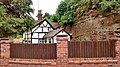 A half-timbered cottage on The Cottages road in Wolverley that has back rooms built into the sandstone cliff.