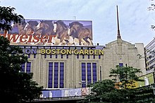 Photo extérieure partielle du Boston Garden caché en partie par des arbres.