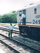 Station master passing the key token to the fireman of the train that was waiting on the loop for another train to pass, at the old Batu Gajah Railway Station in 2002.