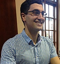 Photograph of Will Kostakis at lectern