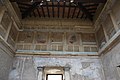 sous un plafond de poutres, murs décoré de pilatres et balustrades en croisillons
