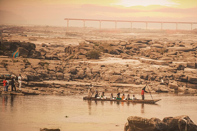 Des gens sur le pirogue au bord du fleuve Congo tout près des rochers sur la place Mbudi Nature