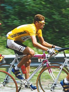 Photographie d'un cycliste en course portant un maillot jaune.