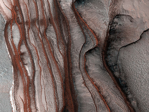Strates sur les pentes de Chasma Boreale, vallée qui s'enfonce dans la calotte polaire. L'image fait 1 km de droite à gauche et la dénivelée est également de 1 km.