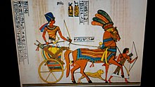 Image en couleurs du pharaon debout sur son char tiré par un cheval devancé par un archer.