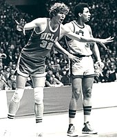 Walton on the court with his arms extended