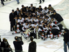 The Hitmen posing as a team on the ice with a trophy