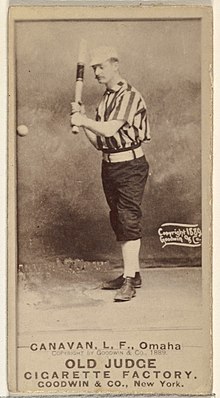 Standing man in baseball uniform with bat