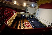 A photo of two levels of seats facing the stage to the right