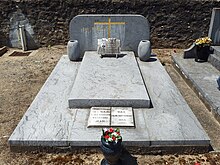 Une tombe dans un cimetière, ornée de plaques funéraires.