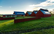 A large building looking like four connected red barns.