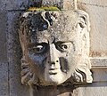 Un mascaron à gauche du portail.