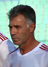 A middle-age man lining up to play association football