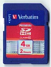 A small blue memory card, not much larger than a postage stamp, with "Verbatim 4 GB 2 hours" printed on it
