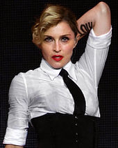 A blond woman wearing a white shirt and black necktie.
