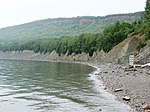 Cliff at the water margin, forest on top