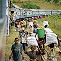 People gathered around a stationary train in Tanzania to sell goods to the passengers. Part of the series Nairobi to Cape Town.