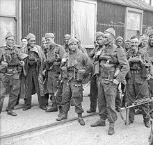 A group of 15 men in uniform carrying weapons