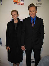 A picture of Conan O'Brien to the right and his wife to the left