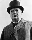 Churchill is wearing his trademark overcoat and top hat.