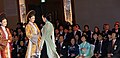 The two women that are wearing the áo dài are both wearing a kiềng.