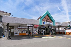 車站東口（2022年5月） 站名牌上有《蠟筆小新》中小新與小白的看板