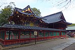 A wooden building with a hip and gable style roof.
