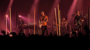 Queens of the Stone Age performing in November 2017. Left to right: Dean Fertita, Josh Homme, Jon Theodore, and Michael Shuman. Not pictured: Troy Van Leeuwen.