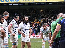 Photo de 5 joueurs en maillot blanc se tenant debout les mains sur les hanches