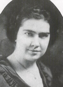 A young white woman with dark curly hair and dark eyes