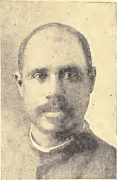 Photo ancienne en noir et blanc : portrait d'un homme moustachu au front dégarni.