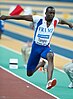 a man in a French team vest jumping along a red running track