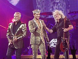 Queen + Adam Lambert in July 2014, performing at SAP Center in San Jose, from left to right: Roger Taylor, Adam Lambert, Brian May