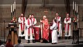 Sacerdotes luteranos usando batinas com estola, e no centro um clérigo de casula.