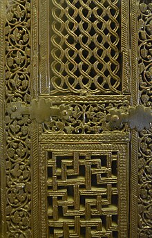 Photographie de deux panneaux du minbar. Ces panneaux sont entourés de bandeaux à décor de rinceaux. Les pièces, réunies par des tenons et des mortaises, sont consolidées par des ferrures.