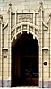 Tall arched doorway surrounded by ivory-colored masonry and ornamentation
