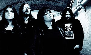 A black-and-white photo of The Magic Numbers leaning and sitting