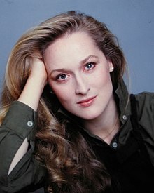 A headshot of Meryl Streep in the 1970s with her facing the camera with her right arm propping her head up