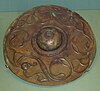 Circular bronze shield with a domed boss and two stylised bird designs