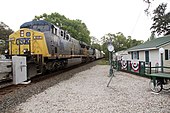 Freight train passing a small building