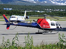 Helicopter coloured red, white, and blue. The text "Helitrans" is written on the side of the aircraft, with "LN-OFG" written above