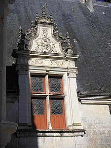 Window with a lucarne, raised above the roof and framed with sculpted pilasters, characteristic of French Renaissance style