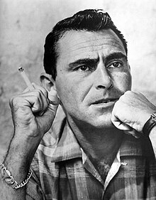 Dark-haired man holding a lit cigarette