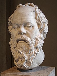 A white marble bust of Socrates with a pug nose and long beard