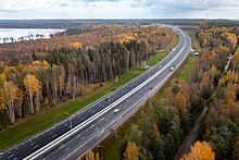 La route fédérale A181, en 2x3 voies, en vue aérienne, avec de chaque côtés des étendues de taïga aux couleurs automnales.